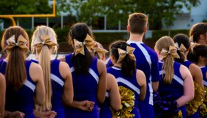 picture of the backs of cheerleaders for the blog "How Much Does Cheerleading Insurance Cost"